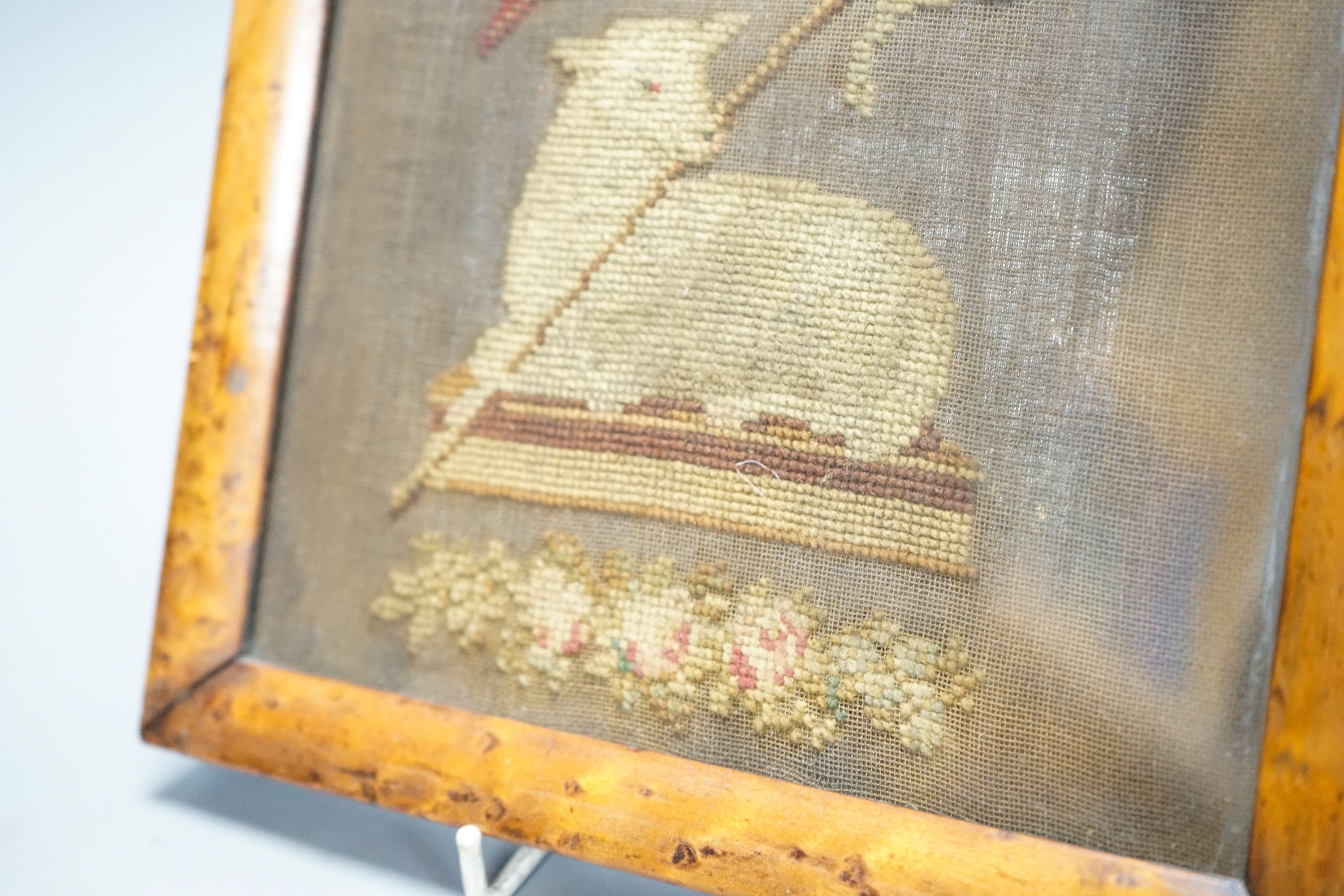 An early 19th century needlework of the Agnus Dei with the vexillum, incorporating a lamb and flag, in bird's eye maple frame 25x23cm incl frame